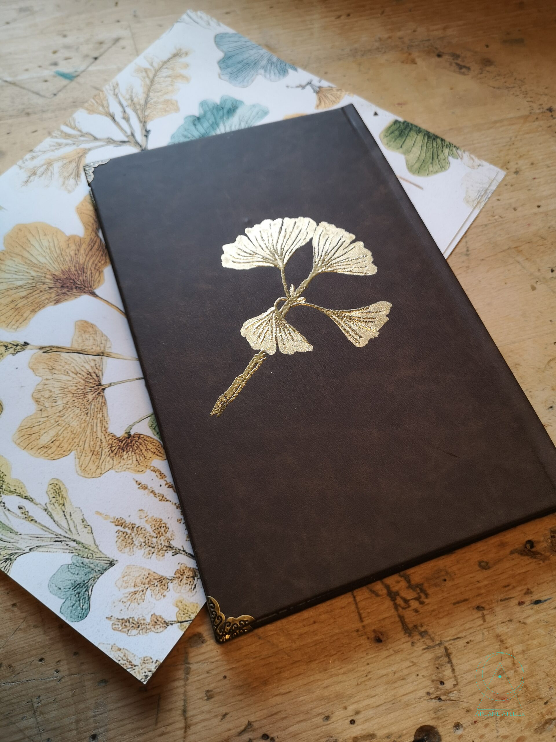 Back cover of the Ginkgo Ledger showing a single gold-embossed ginkgo branch with four leaves.